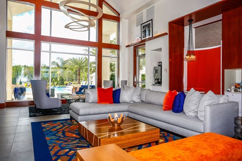 a living room with couches and a coffee table and large windows